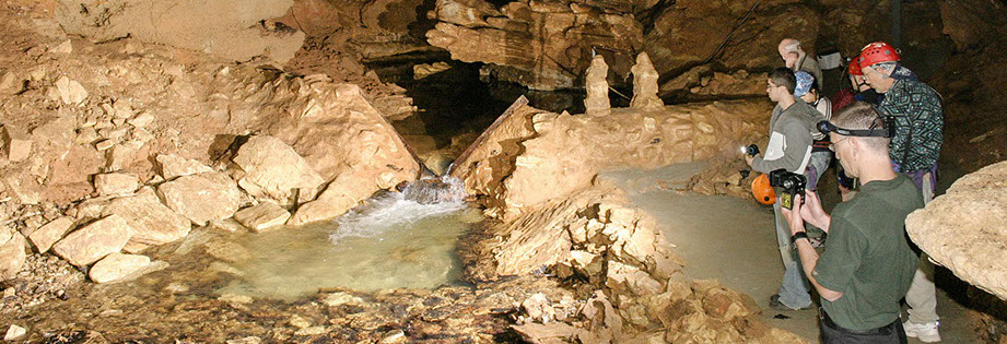 Field Trip Underground Tour learning about water flow at the wier in Tumbling Creek as it flows through the cave